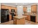 Well-equipped kitchen featuring granite counters, wood cabinets, and island at 202 Verrazano Pl, Clayton, NC 27520