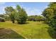 A view of the landscaped backyard with a lush lawn and mature shade trees at 2040 Persimmon Ridge Dr, Raleigh, NC 27604