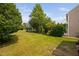 A view of the landscaped backyard with a lush lawn and mature shade trees at 2040 Persimmon Ridge Dr, Raleigh, NC 27604
