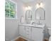 Elegant bathroom with double vanity featuring quartz countertops, mirrors, and natural light at 2040 Persimmon Ridge Dr, Raleigh, NC 27604