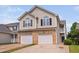 Well-maintained townhouse featuring a two-car garage, brick accents, and stylish architectural details at 2040 Persimmon Ridge Dr, Raleigh, NC 27604