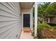 Charming front entrance with a stylish black door, welcome mat, and neatly trimmed landscaping at 2040 Persimmon Ridge Dr, Raleigh, NC 27604