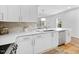 This bright kitchen features white cabinets, stainless appliances, and a light tile backsplash at 2040 Persimmon Ridge Dr, Raleigh, NC 27604