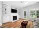 Living room with built in shelving, fireplace, wood look floors and access to an enclosed porch at 2040 Persimmon Ridge Dr, Raleigh, NC 27604