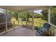 Open screened-in porch with cozy seating and panoramic views of the well-maintained backyard at 2040 Persimmon Ridge Dr, Raleigh, NC 27604