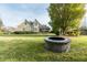 Spacious backyard featuring lush lawn, a stone fire pit, and ample space for outdoor entertaining at 2100 Stone Pasture Rd, Fuquay Varina, NC 27526