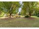 Landscaped backyard with mature trees and shrubs, offering a serene and picturesque outdoor space at 2100 Stone Pasture Rd, Fuquay Varina, NC 27526