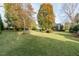 Beautiful backyard with mature trees, manicured lawn, and serene landscaping offers a peaceful outdoor retreat at 2100 Stone Pasture Rd, Fuquay Varina, NC 27526