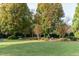 Expansive backyard featuring manicured lawn, mature trees, and lush landscaping provides serene outdoor living at 2100 Stone Pasture Rd, Fuquay Varina, NC 27526