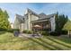 Backyard with lush lawn, stone patio, screened porch, mature trees, and grill at 2100 Stone Pasture Rd, Fuquay Varina, NC 27526