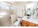 Modern bathroom featuring tiled walk-in shower, toilet, and wooden vanity with a large mirror at 2100 Stone Pasture Rd, Fuquay Varina, NC 27526