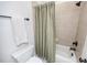 Full bathroom with tile flooring, toilet, and shower with neutral beige shower curtain at 2100 Stone Pasture Rd, Fuquay Varina, NC 27526