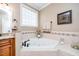 Bathroom featuring a jacuzzi tub with tile surround, granite countertops and hardware at 2100 Stone Pasture Rd, Fuquay Varina, NC 27526