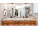 Bathroom with double granite vanity sinks and cabinets, and a large mirror at 2100 Stone Pasture Rd, Fuquay Varina, NC 27526