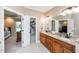 Bathroom with double granite vanity sinks and cabinets, leading to bedroom and closet at 2100 Stone Pasture Rd, Fuquay Varina, NC 27526