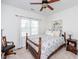 Well-lit bedroom features a ceiling fan, wood-trimmed bed and window with curtains at 2100 Stone Pasture Rd, Fuquay Varina, NC 27526