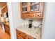 Charming coffee bar niche with upper and lower wood cabinets, granite countertops, and tile backsplash at 2100 Stone Pasture Rd, Fuquay Varina, NC 27526