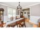 Elegant dining room featuring a wooden table, wainscoting, and a view of the front entryway at 2100 Stone Pasture Rd, Fuquay Varina, NC 27526