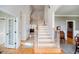 Bright foyer featuring hardwood floors, staircase, and an open view to the home's living spaces at 2100 Stone Pasture Rd, Fuquay Varina, NC 27526