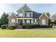 Charming two-story home featuring a manicured lawn, stone accents, and a welcoming front porch at 2100 Stone Pasture Rd, Fuquay Varina, NC 27526