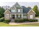 Charming home featuring a stone and siding facade, inviting front porch, and well-manicured lawn at 2100 Stone Pasture Rd, Fuquay Varina, NC 27526