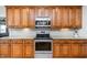 Kitchen with a stainless steel oven and microwave, wood cabinetry, and granite counter tops at 2100 Stone Pasture Rd, Fuquay Varina, NC 27526