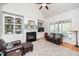 Inviting living room with a cozy fireplace, built-in shelving, and large windows for natural light at 2100 Stone Pasture Rd, Fuquay Varina, NC 27526