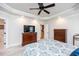Main bedroom with decorative ceiling fan, carpeted floors, wooden dressers, and TV at 2100 Stone Pasture Rd, Fuquay Varina, NC 27526