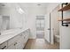 Bright bathroom featuring double vanity, framed mirror and sleek black plumbing fixtures and adjacent water closet at 214 George Pine Way, Knightdale, NC 27545