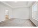 Spacious bedroom with neutral carpeting, tray ceiling, and a large window at 214 George Pine Way, Knightdale, NC 27545