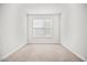 Neutral-toned bedroom features window with blinds and plush carpeting for a cozy and inviting atmosphere at 214 George Pine Way, Knightdale, NC 27545