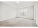Spacious bedroom with neutral carpeting, tray ceiling, and a large window at 214 George Pine Way, Knightdale, NC 27545