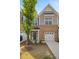 Beautiful brick townhome with an attached garage and gray siding, complemented by a well-maintained lawn at 214 George Pine Way, Knightdale, NC 27545