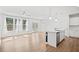 Bright and open-concept kitchen and living area with hardwood floors, modern lighting, and stainless steel appliances at 214 George Pine Way, Knightdale, NC 27545