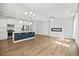 Bright open-concept living area and kitchen featuring hardwood floors, modern lighting, and a sleek linear fireplace at 214 George Pine Way, Knightdale, NC 27545