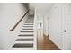 Elegant staircase with hardwood steps and white risers, leading to a bright and airy upper level at 214 George Pine Way, Knightdale, NC 27545