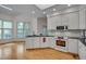 The kitchen has white cabinets, black countertops, stainless steel appliances, and hardwood floors at 2312 Shallowford Ln, Chapel Hill, NC 27517