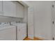 Laundry room with washer and dryer, white cabinets and door to closet at 2312 Shallowford Ln, Chapel Hill, NC 27517