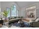 Staged living room filled with furniture and a large arched window overlooking the landscaped yard at 2312 Shallowford Ln, Chapel Hill, NC 27517