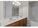 Bathroom with double sink vanity, large mirror, and a shower-tub combo at 2740 Laurelcherry St, Raleigh, NC 27612