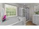 Bright bathroom featuring a garden tub, a separate shower, and a window to the outdoors at 2740 Laurelcherry St, Raleigh, NC 27612