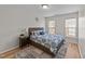 Comfortable bedroom featuring a wooden bed frame, stylish rug, and bright natural light from two windows at 2740 Laurelcherry St, Raleigh, NC 27612