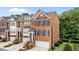 Elegant brick townhome with manicured landscaping, blue shutters, and a convenient attached garage at 2740 Laurelcherry St, Raleigh, NC 27612