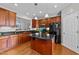 Well-lit kitchen boasts wood cabinets, granite countertops, a large island and black appliances at 2740 Laurelcherry St, Raleigh, NC 27612