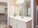 Bright bathroom featuring white cabinets and a large vanity mirror at 301 Monterey Ct, Benson, NC 27504