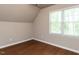 Neutral bedroom featuring wood-look flooring, a large window, and overhead lighting at 301 Monterey Ct, Benson, NC 27504