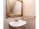 Cozy half-bathroom features a pedestal sink, ornate mirror, and gold hardware at 301 Monterey Ct, Benson, NC 27504