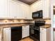 Bright kitchen features white cabinets, granite countertops, and modern black appliances at 301 Monterey Ct, Benson, NC 27504