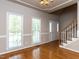 Bright living room with hardwood floors, staircase, and large windows with natural light at 301 Monterey Ct, Benson, NC 27504