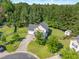 Aerial view of the home with fenced yard, mature trees, and neighborhood at 303 Sylvias Ct, Durham, NC 27703